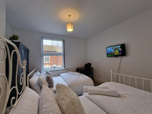 レスターにあるNice Living Serviced Accommodations Leicester 2のベッド2台と薄型テレビ付きのベッドルーム