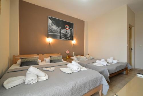 a group of three beds in a room at Εlvina apartments in Leptokaria