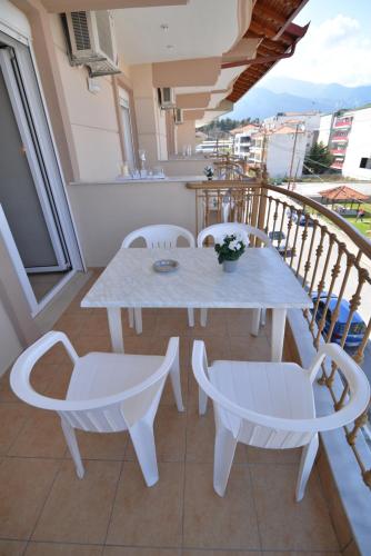 a white table and chairs on a balcony at Εlvina apartments in Leptokaria