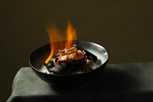 a black bowl of food with flames in it at Park Hyatt Shenzhen in Shenzhen