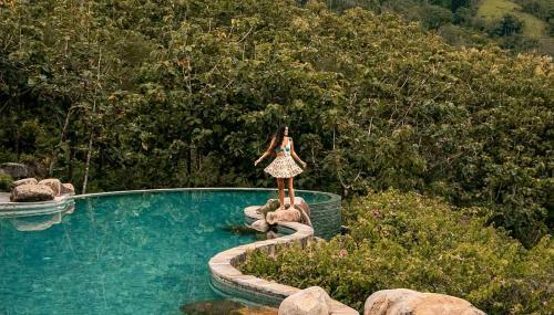 a woman in a dress standing next to a swimming pool at MATHIS Lodge Amed in Amed
