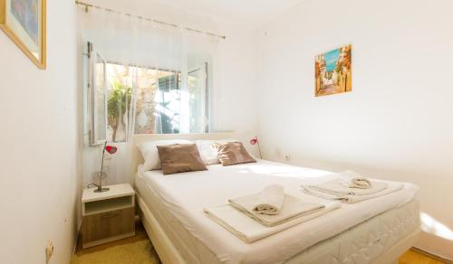 a bedroom with a large white bed with a window at Dubrovnik center apartment in Dubrovnik