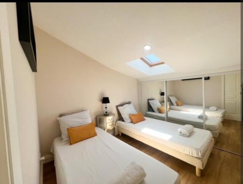 une chambre avec deux lits et un miroir dans l'établissement Appartement, proche du palais des festivals, plage et commerces, à Cannes
