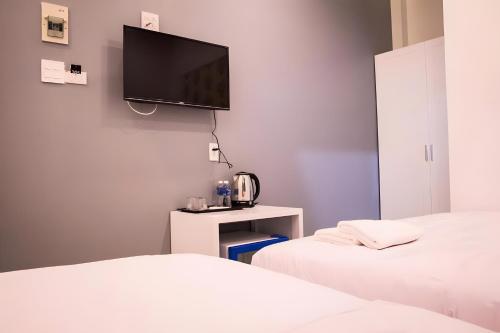 a room with two beds and a tv on the wall at 1991 Hotel Phan Thiết in Phan Thiet