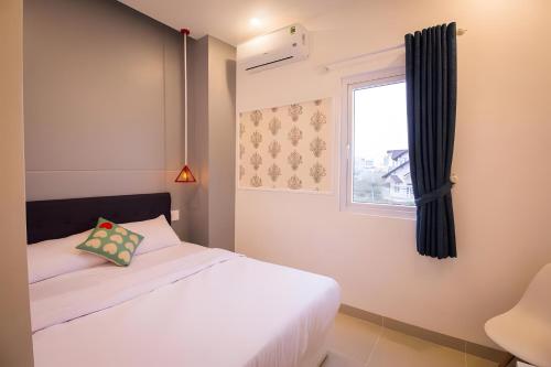 a bedroom with a white bed and a window at 1991 Hotel in Phan Thiet