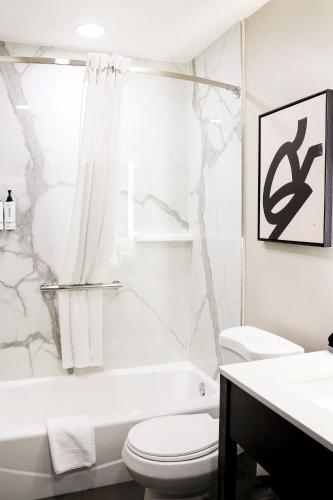 a white bathroom with a toilet and a sink at voco Flagstaff by IHG in Flagstaff