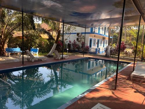 a swimming pool in front of a house at Dom Pedros Haven Resort - Tranquil Retreat by the Sea in Utorda