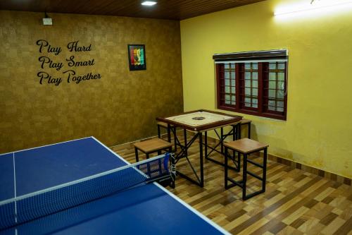 a ping pong room with a ping pong table and a tennis court at Hill Valley Farm House in Nelliyampathy