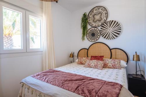 a bedroom with a bed with a wooden headboard and two windows at Apartamentos Zahora 37 in Zahora