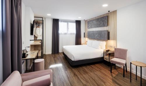 a hotel room with a bed and a desk at Sercotel Córdoba Delicias in Córdoba