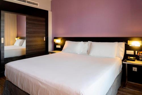 Postel nebo postele na pokoji v ubytování Sercotel Córdoba Medina Azahara