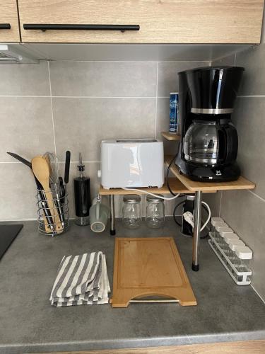 - un comptoir de cuisine avec une cafetière sur une étagère dans l'établissement Studio the cosy, à Béziers
