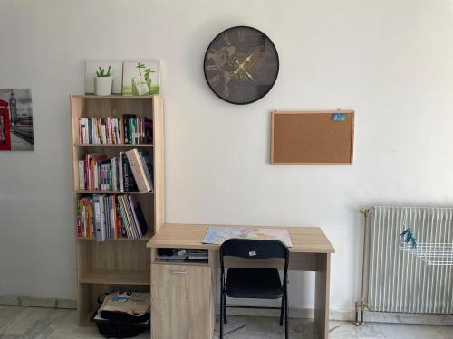 un bureau avec une chaise et un réveil sur un mur dans l'établissement Studio the cosy, à Béziers