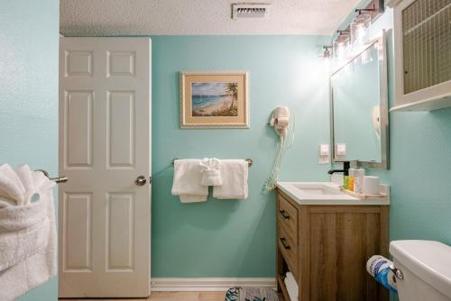 a bathroom with blue walls and a sink and a mirror at Seaside Serenity - Destin, FL in Destin