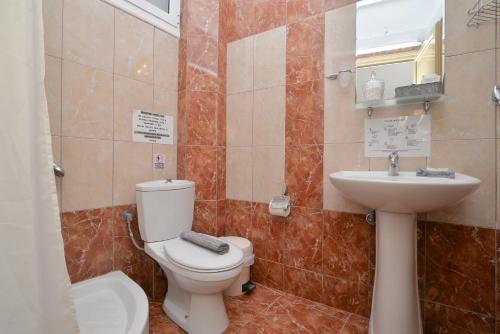 a bathroom with a toilet and a sink at Εlvina apartments in Leptokaria