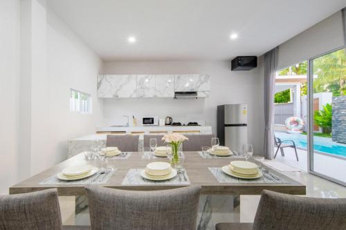 a dining room and kitchen with a table and chairs at Sasi Pool Villa Phuket in Rawai Beach