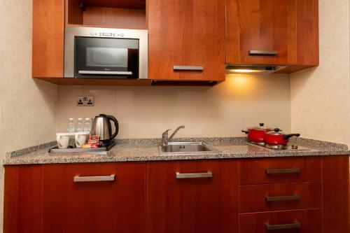a kitchen with a sink and a microwave at Holiday Inn Kuwait by IHG in Kuwait