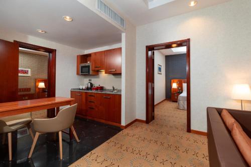 a kitchen with a desk and a dining room at Holiday Inn Kuwait by IHG in Kuwait