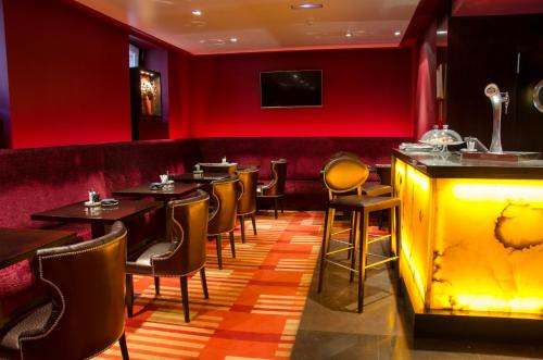 a restaurant with red walls and tables and chairs at Hotel Boutique Gareus in Valladolid