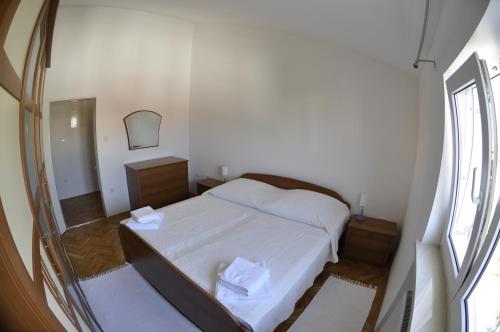 een kleine slaapkamer met een bed en een spiegel bij Apartments Trogir in Trogir