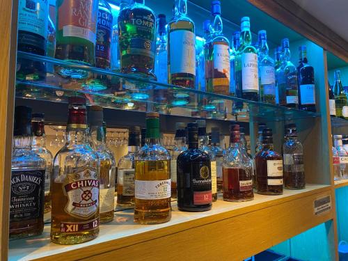a shelf filled with lots of bottles of alcohol at Onich Hotel & Lochside Beach Pods in Onich