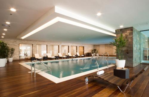 a hotel lobby with a pool and chairs at Swissotel Lima in Lima