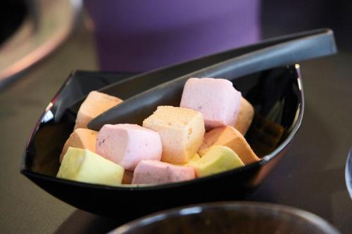 a black bowl filled with different types of food at Campanile Roissy - Aéroport CDG - Le Mesnil Amelot in Le Mesnil-Amelot