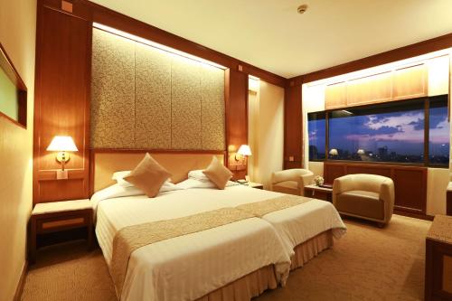 a hotel room with a bed and a large window at Asia Hotel Bangkok in Bangkok