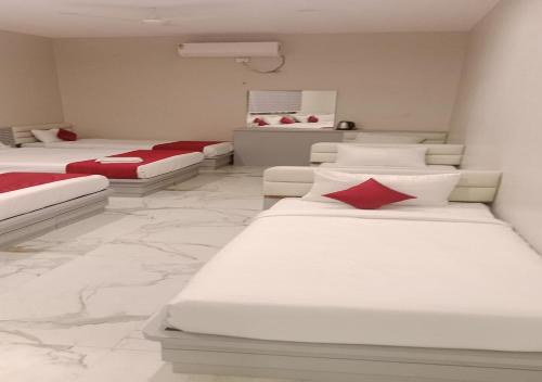 a room with four beds with red pillows on them at Sam Eden Resort in Bengaluru