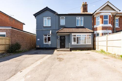 a blue house with a driveway in front at Elena Apartment in Southampton