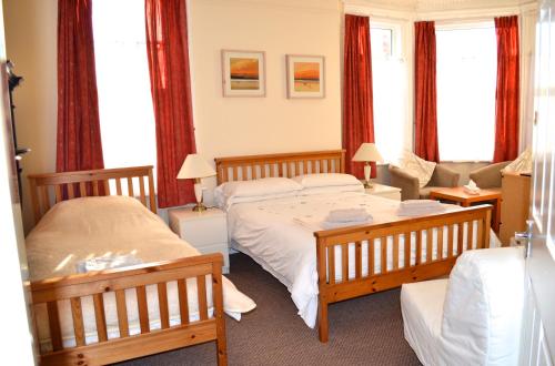 a bedroom with two beds and a couch at The Avenue Bed and Breakfast in Newcastle upon Tyne