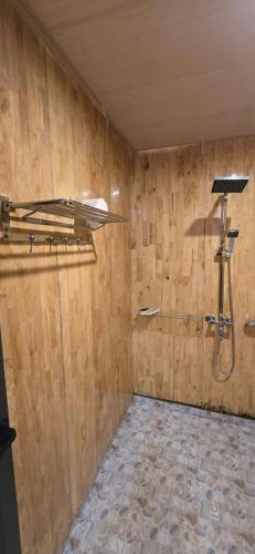 a bathroom with a shower in a wooden wall at Pú Nhu House Mù Cang Chải in Mù Cang Chải