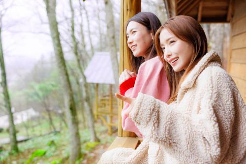 two young women looking out the window of a cabin at Hida-Osaka Fureai no Mori Bungalow in Gero