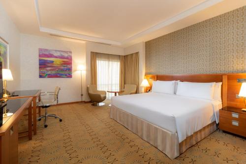 a hotel room with a bed and a desk at Holiday Inn - Suites Kuwait Salmiya by IHG in Kuwait