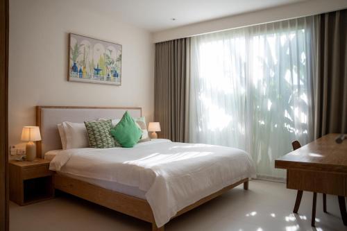 a bedroom with a bed and a window and a desk at Modern 3BR Pool Villa T-Breeze in Laguna Phuket