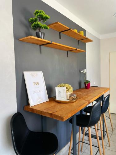 a dining room table with stools and shelves on the wall at "Ferienwohnung Naturliebe - grünes Paradies im Zentrum in Luckenwalde
