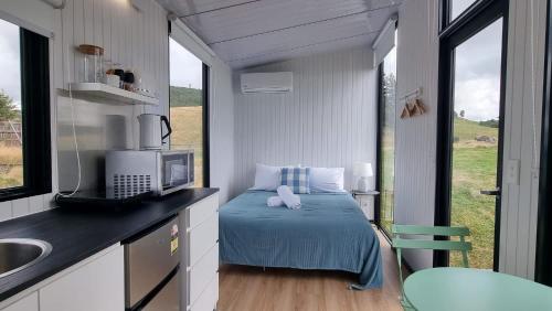 a small bedroom with a bed in a tiny house at Aorangi Peak Cabins 8 by Tiny Away in Rotorua