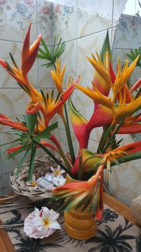 a vase filled with flowers on a table at SCO Lodge in Punaauia