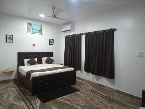 a bedroom with a bed and a black curtain at Hotel de gracia baga beach in Baga