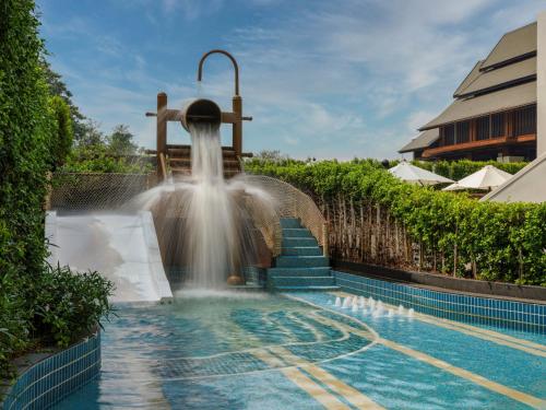 a water fountain in a pool with stairs at InterContinental Chiang Mai The Mae Ping in Chiang Mai