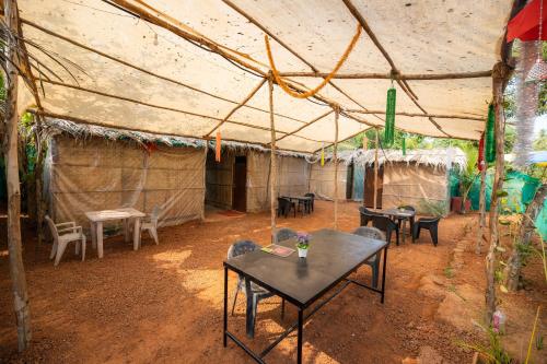 a tent with tables and chairs in a room at Page three stays and backpackers hostel in Anjuna