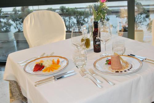 a table with two plates of food and a bottle of wine at Hotel Il Mulino in Capo dʼOrlando