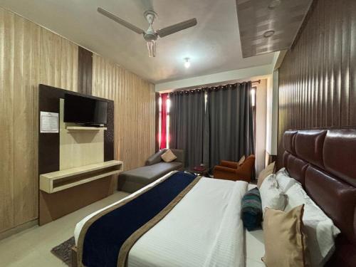 a hotel room with a bed and a flat screen tv at Bob's N Barley in Dharamshala