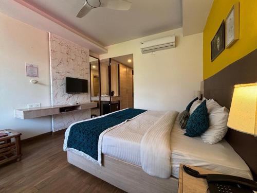 a hotel room with a large bed and a television at Bob's N Barley in Dharamshala