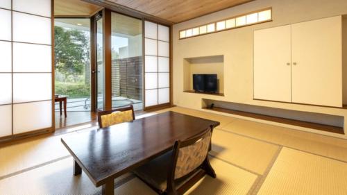 a large dining room with a wooden table and chairs at Kurhouse Shirahama in Shirahama