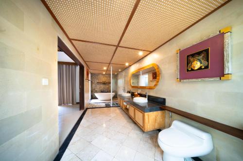 a bathroom with a toilet and a sink at Dedary Resort & Spa Ubud by Ini Vie Hospitality in Ubud