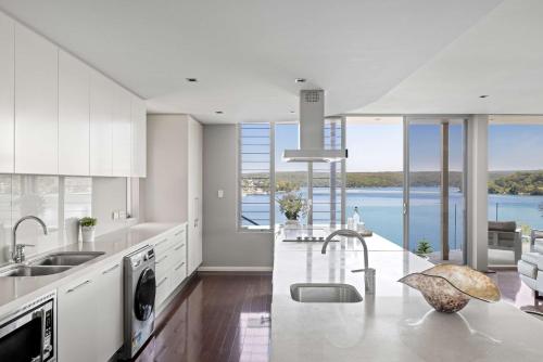 Lilli PilliにあるWaterfront Ensuite Queen Room - Luxury & Comfort Place in Caringbah Southの白いキッチン(水辺の景色を望む)