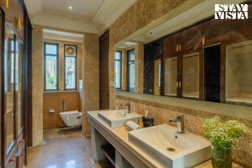 a bathroom with two sinks and a toilet at StayVista at Albatross Haven with BBQ & Bonfire in Noida