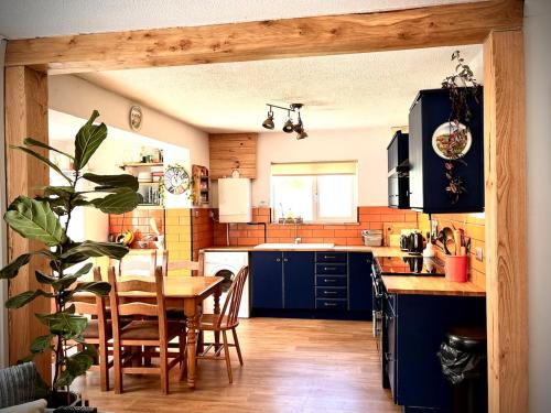 a kitchen with blue cabinets and a table with chairs at Ty Marlyn in St. Davids