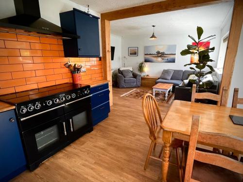 a kitchen and dining room with a stove and a table at Ty Marlyn in St. Davids
